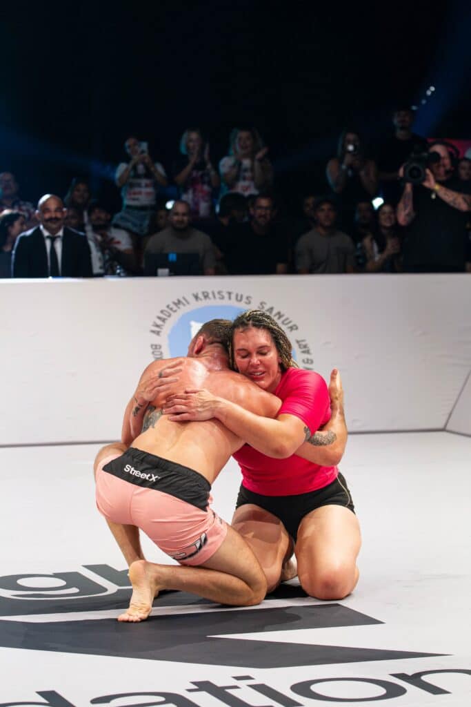 CJI competitors hugging on the mat at an event.